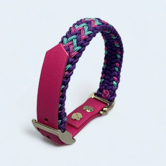 small paracord dog collar in pink and purple upright on a light background.