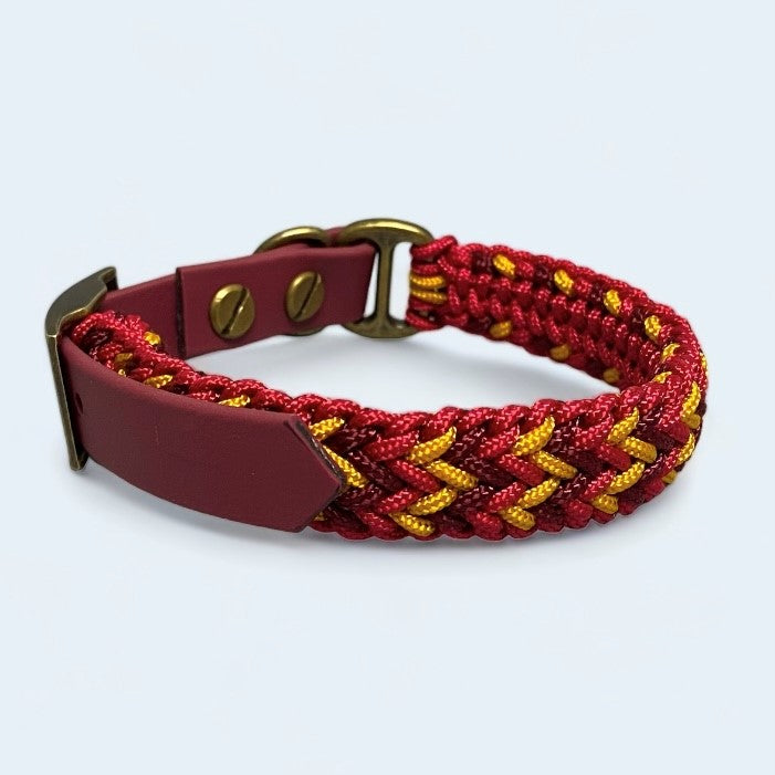 small dog collar in red, burgundy and gold on a light background.