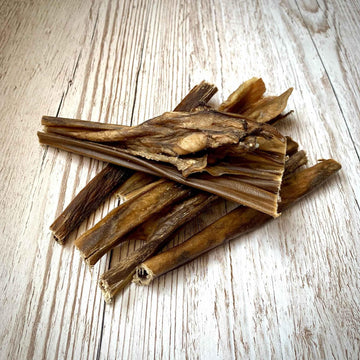 air-dried venison pieces on light wooden background - natural dog chews and treats